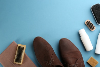 Photo of Stylish footwear with shoe care accessories on light blue background, flat lay. Space for text