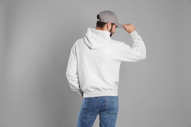 Young man in sweater on grey background. Mock up for design