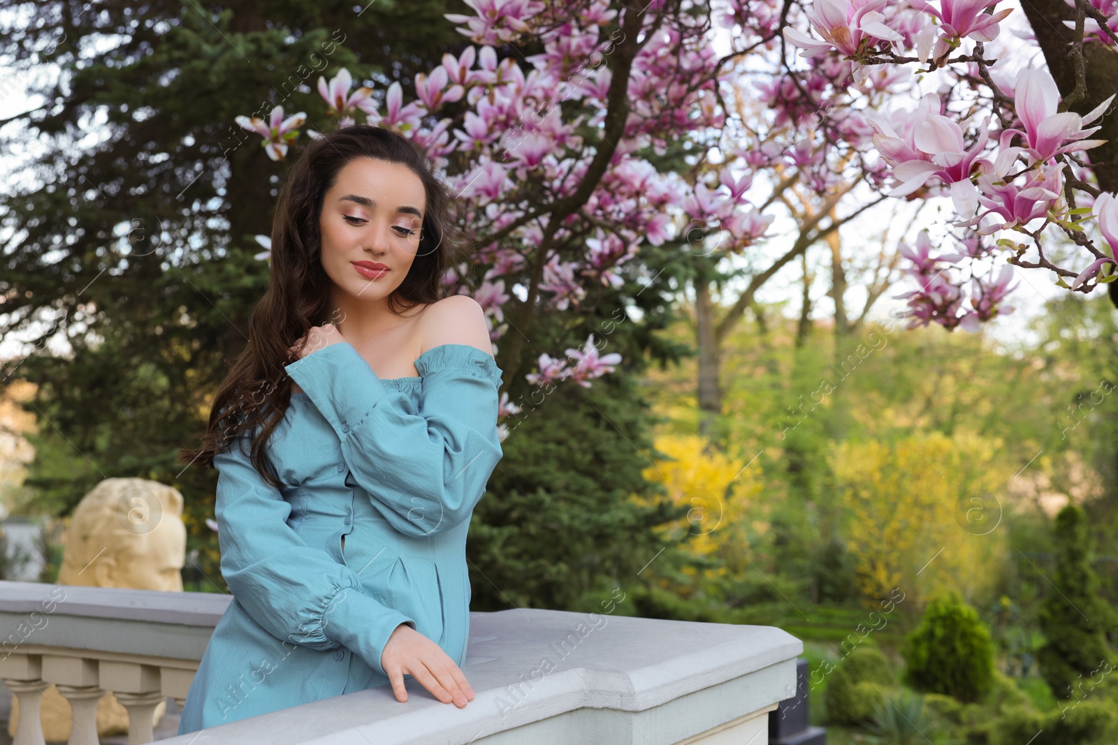 Photo of Beautiful woman near blossoming magnolia tree on spring day