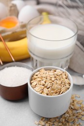 Photo of Different ingredients for cooking tasty oatmeal pancakes on grey table