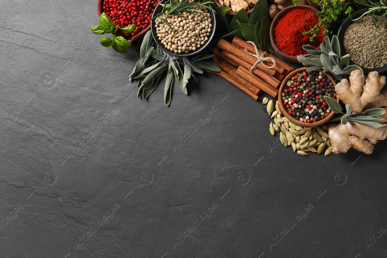 Photo of Different herbs and spices on black table, flat lay. Space for text