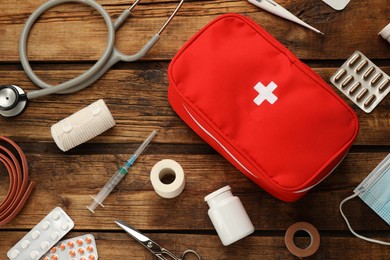 First aid kit on wooden table, flat lay