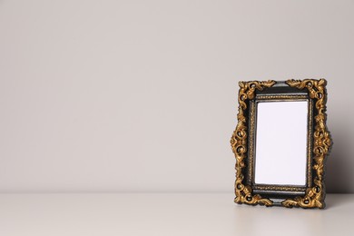Photo of Beautiful vintage empty frame on white table, space for text