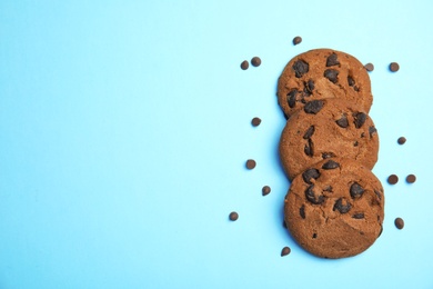 Photo of Delicious chocolate chip cookies on color background, flat lay. Space for text