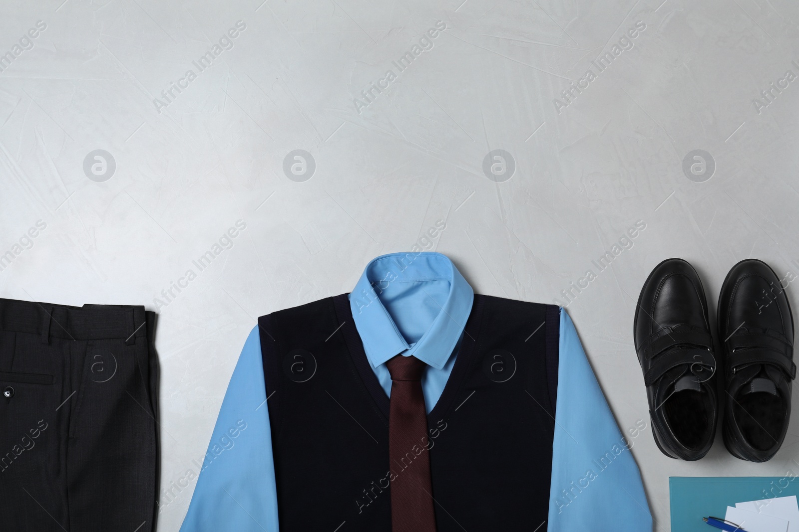 Photo of Flat lay composition with school uniform on light background. Space for text