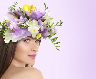 Image of Pretty woman wearing beautiful wreath made of flowers on lilac background, space for text
