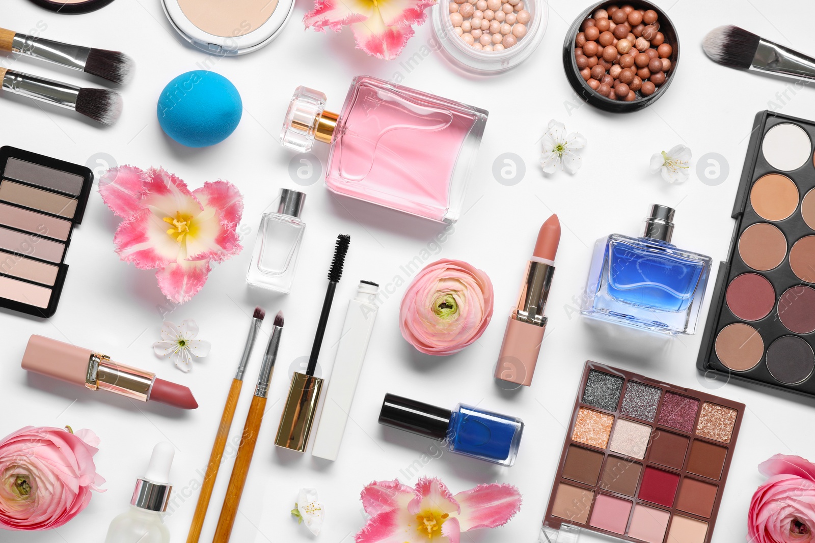 Photo of Flat lay composition with different makeup products and beautiful spring flowers on white background