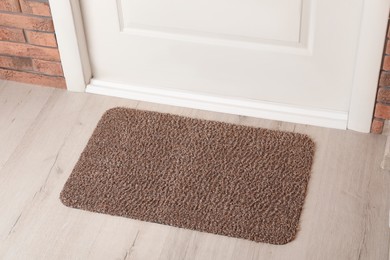 Grey door mat on wooden floor in hall, above view