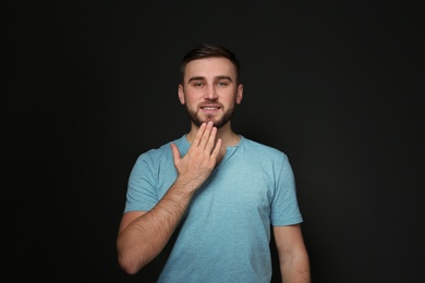 Photo of Man showing THANK YOU gesture in sign language on black background