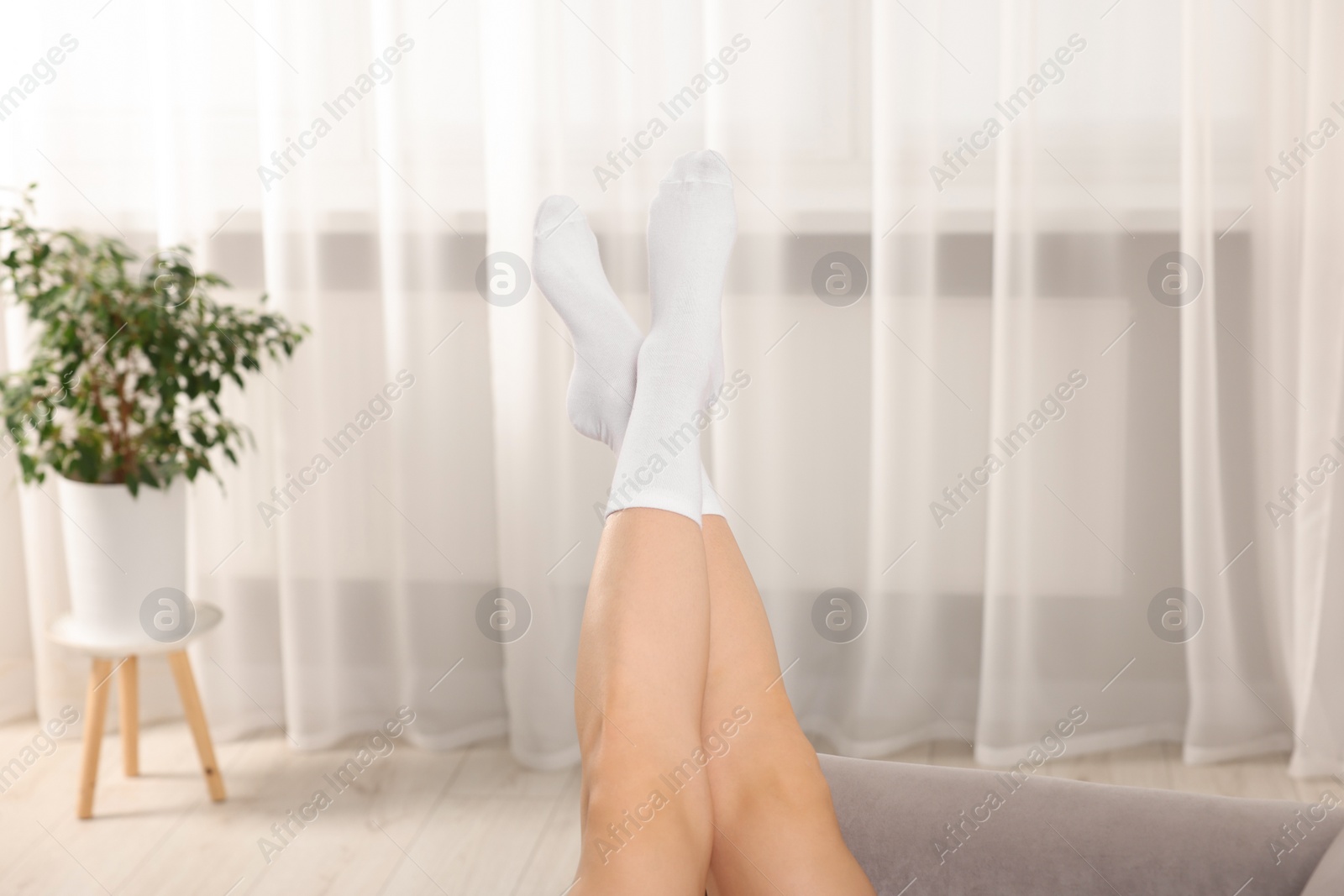 Photo of Woman in stylish white socks indoors, closeup