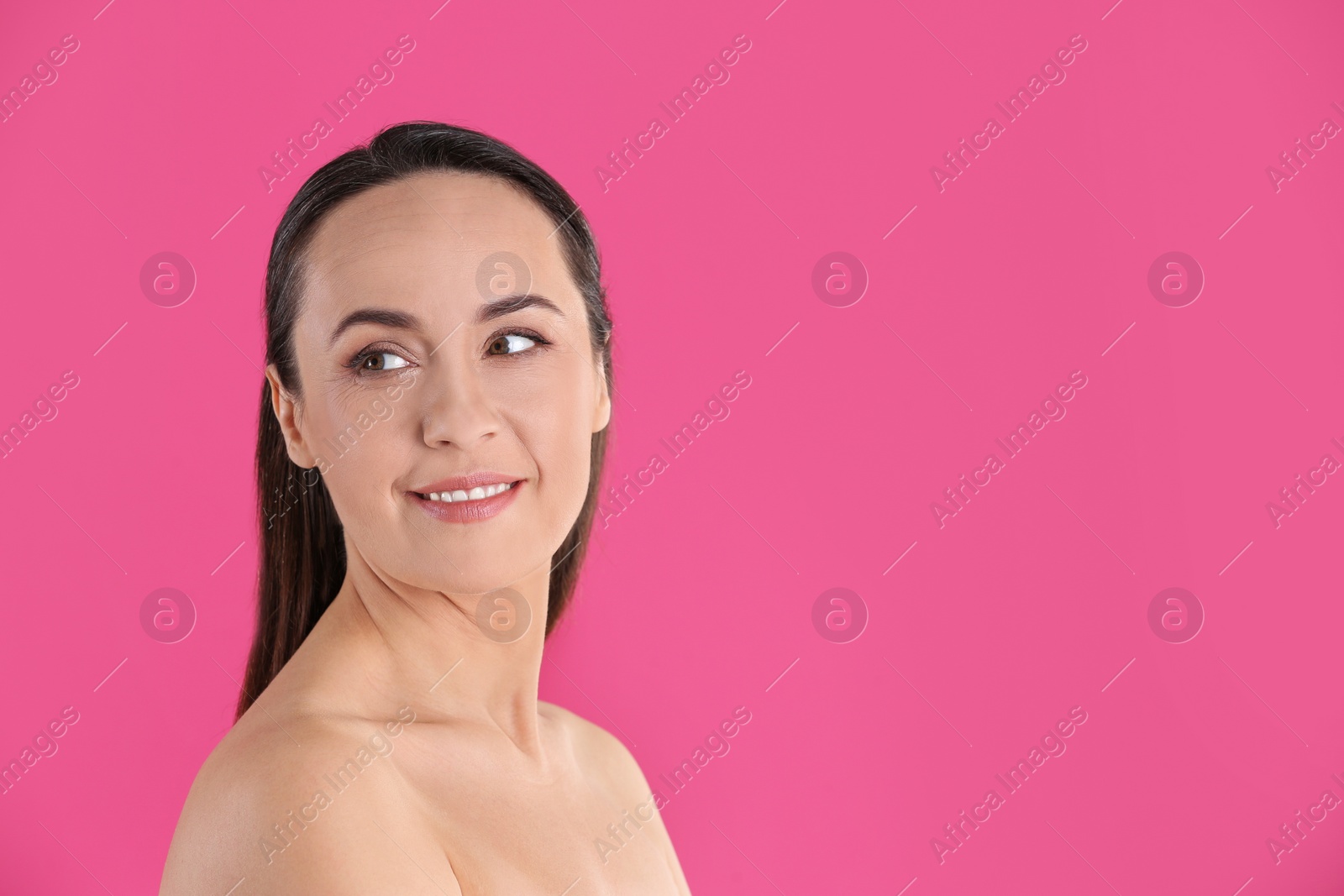 Photo of Portrait of beautiful mature woman on pink background. Space for text