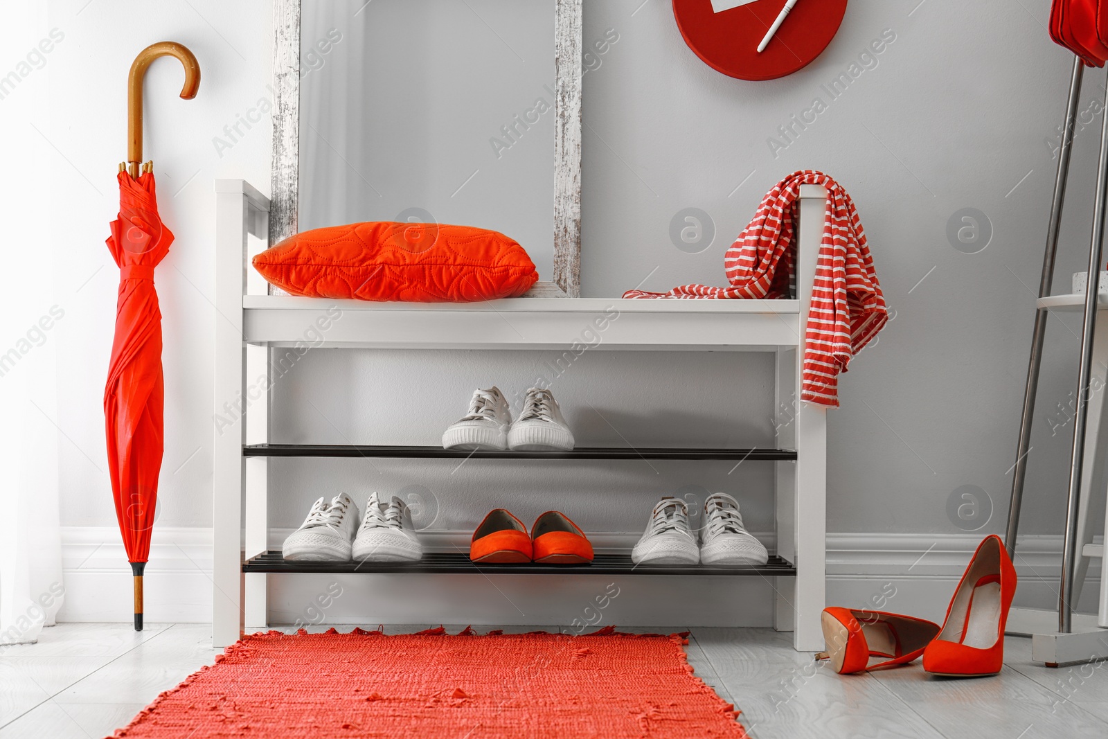 Stylish hallway interior with shoe rack and rug Photo of Stylish hallway interior with shoe rack and rug
