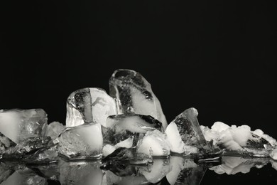 Photo of Pile of crushed ice on black mirror surface