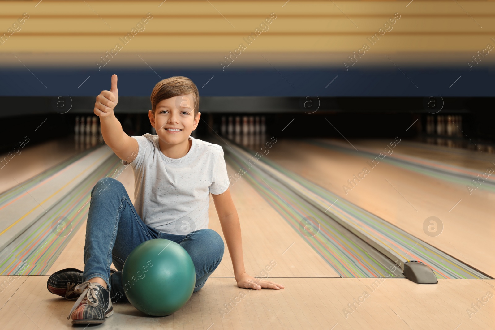 Photo of Preteen boy with ball in bowling club