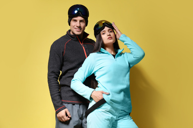 Photo of Couple wearing stylish winter sport clothes on yellow background