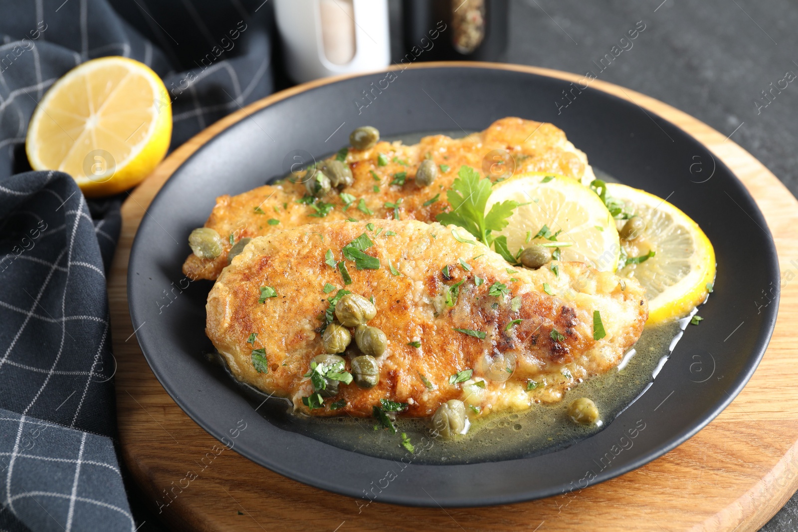 Photo of Delicious chicken piccata served on table, closeup