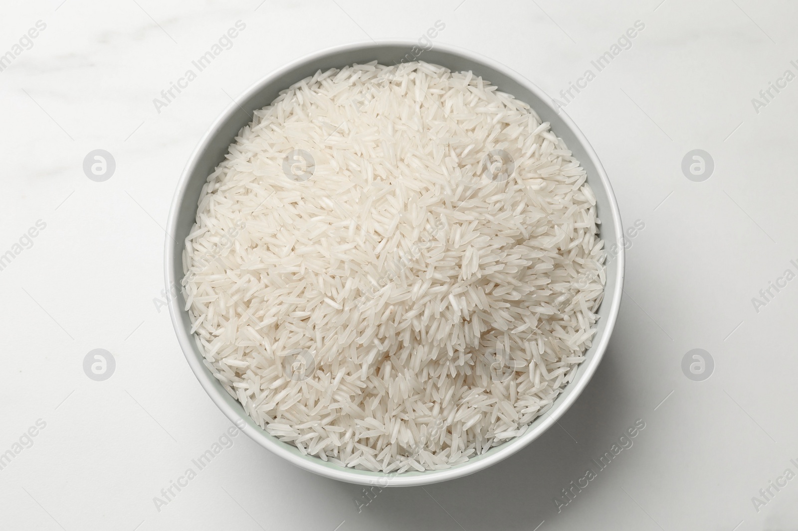 Photo of Raw basmati rice in bowl on white table, top view