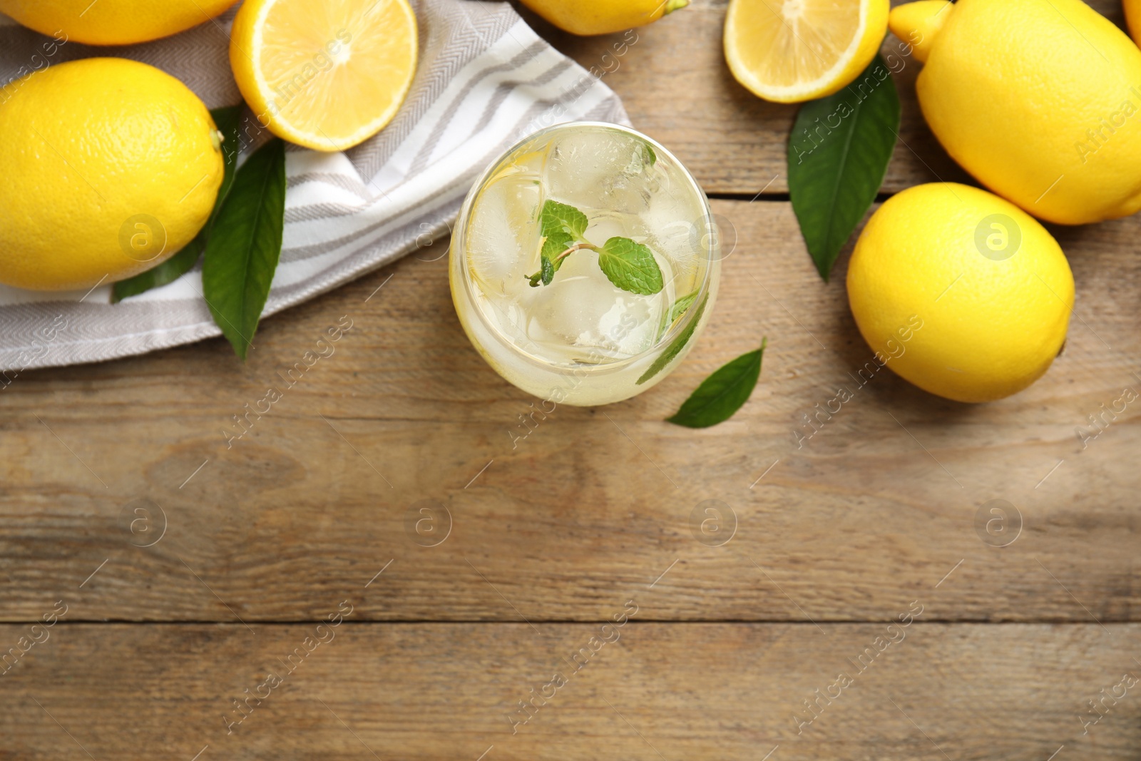 Photo of Cool freshly made lemonade and fruits on wooden table, flat lay. Space for text