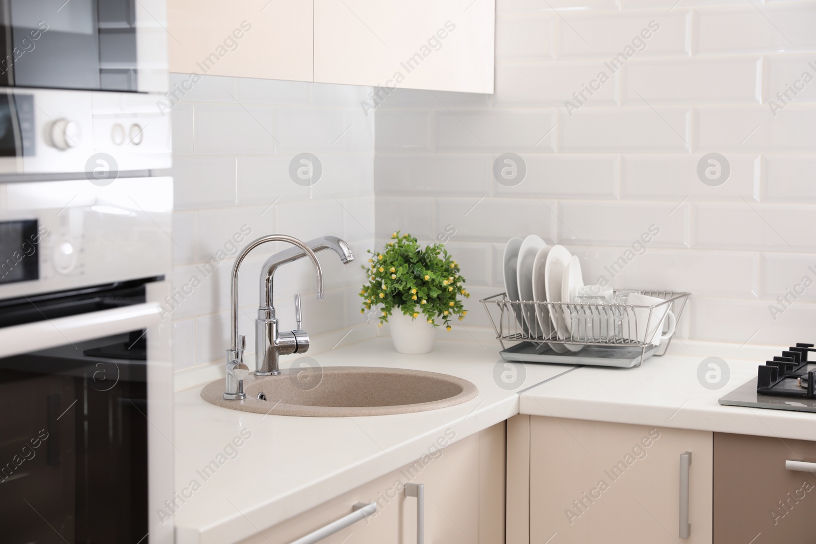 Photo of Clean dishes on counter near kitchen sink indoors