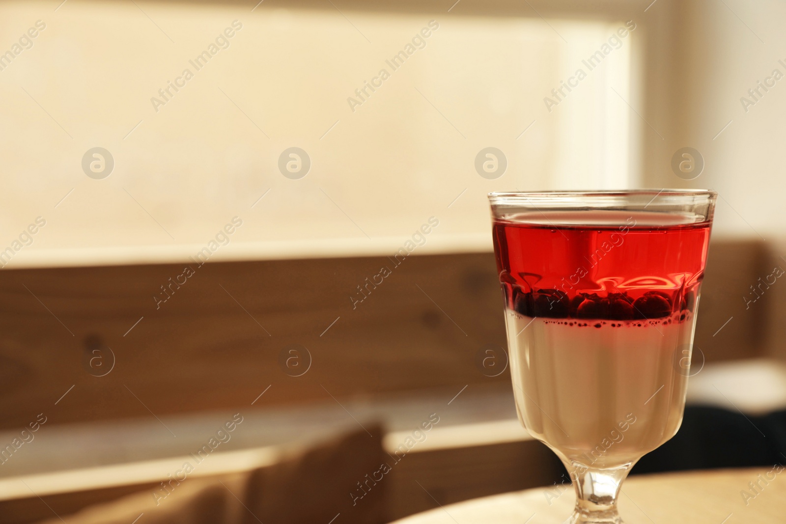 Photo of Delicious panna cotta dessert with berries against blurred background, closeup. Space for text