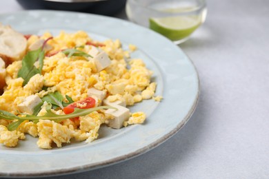 Photo of Plate with delicious scrambled eggs and tofu on white table, closeup