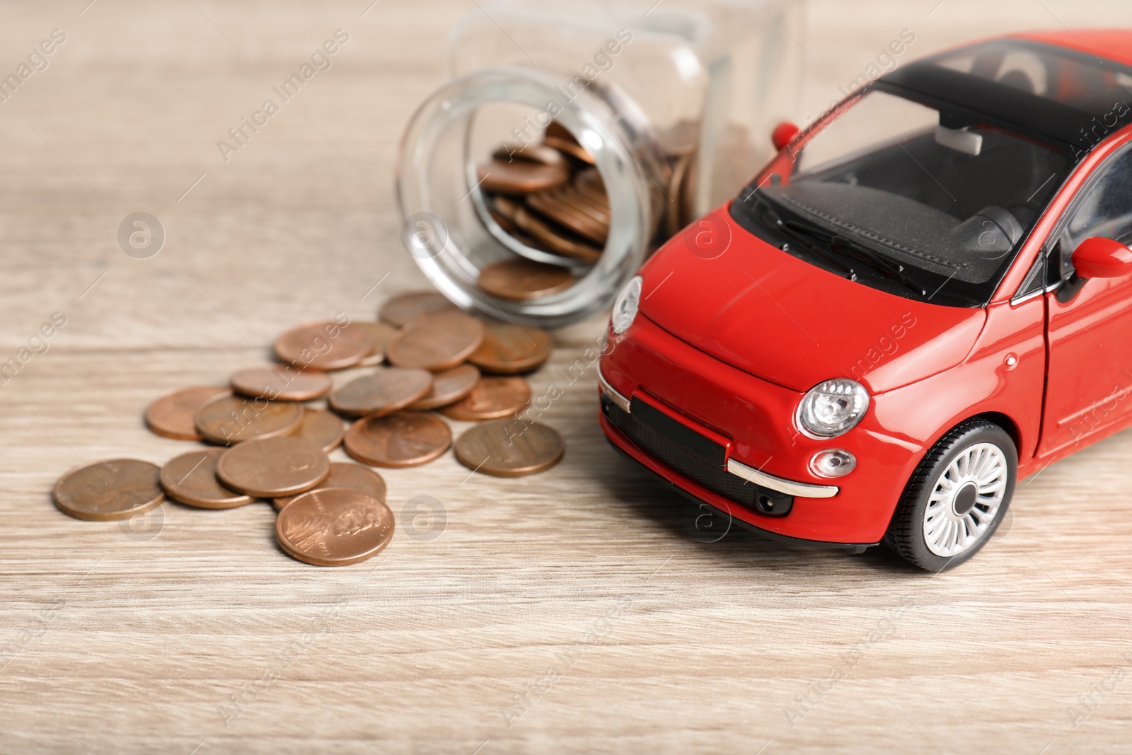 Photo of Toy car and money on table. Vehicle insurance