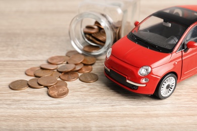 Toy car and money on table. Vehicle insurance