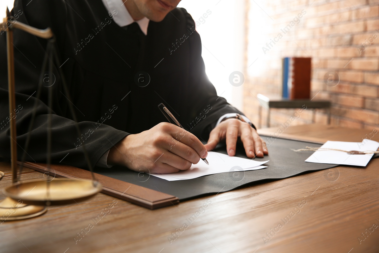 Photo of Judge working with papers at table in office, closeup. Law and justice concept