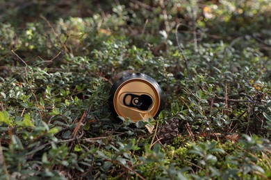 Photo of Used aluminium can on green grass outdoors. Recycling problem