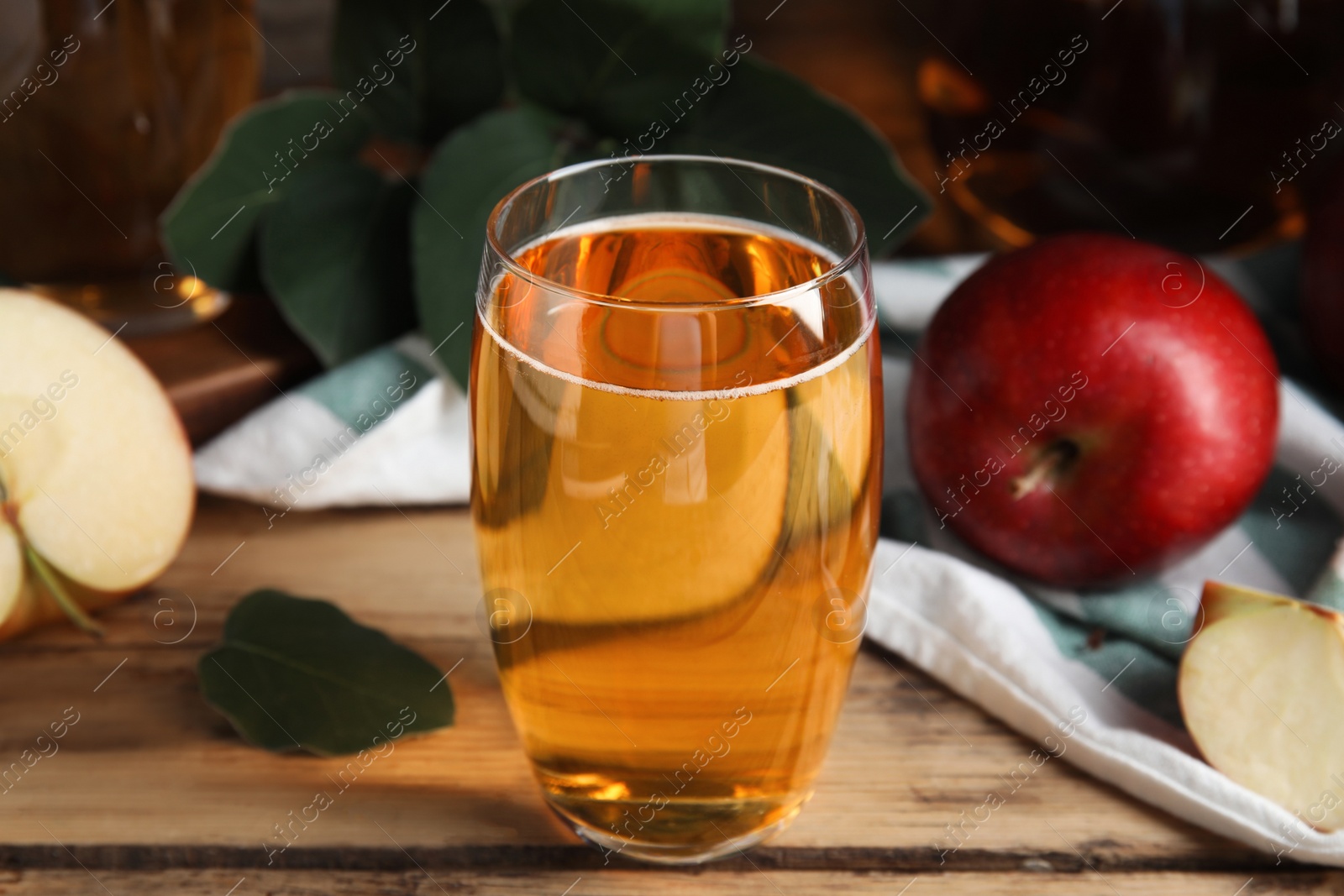 Photo of Glass of delicious apple cider on wooden table