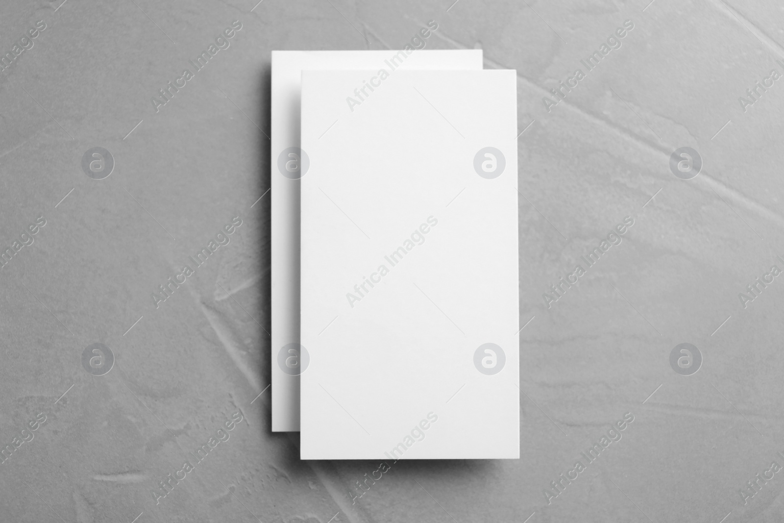 Photo of Blank business cards on light grey stone background, top view. Mock up for design