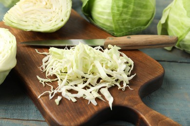 Photo of Chopped cabbage on blue wooden table, closeup