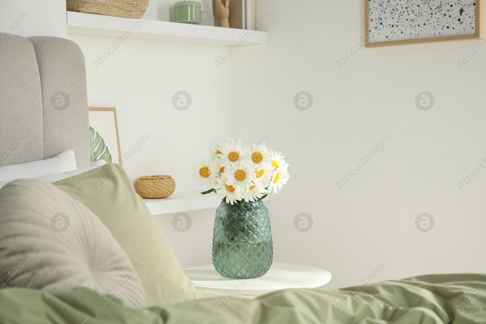 Photo of Bouquet of beautiful daisy flowers on table in bedroom