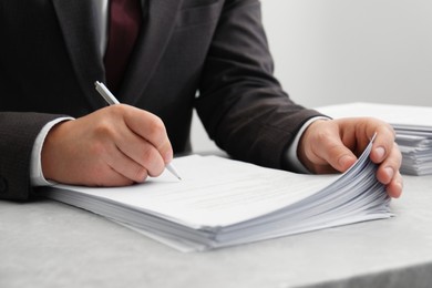 Photo of Man signing document at table in office, closeup