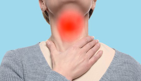 Image of Endocrine system. Woman doing thyroid self examination on light blue background, closeup. Banner design