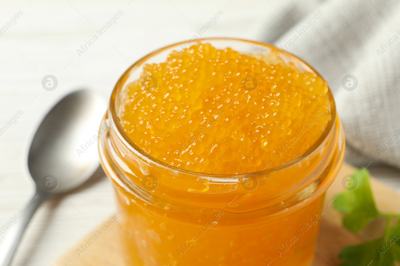 Photo of Fresh pike caviar in glass jar on white table, closeup