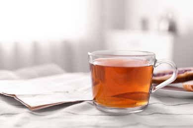 Photo of Morning tea and newspaper on fabric indoors