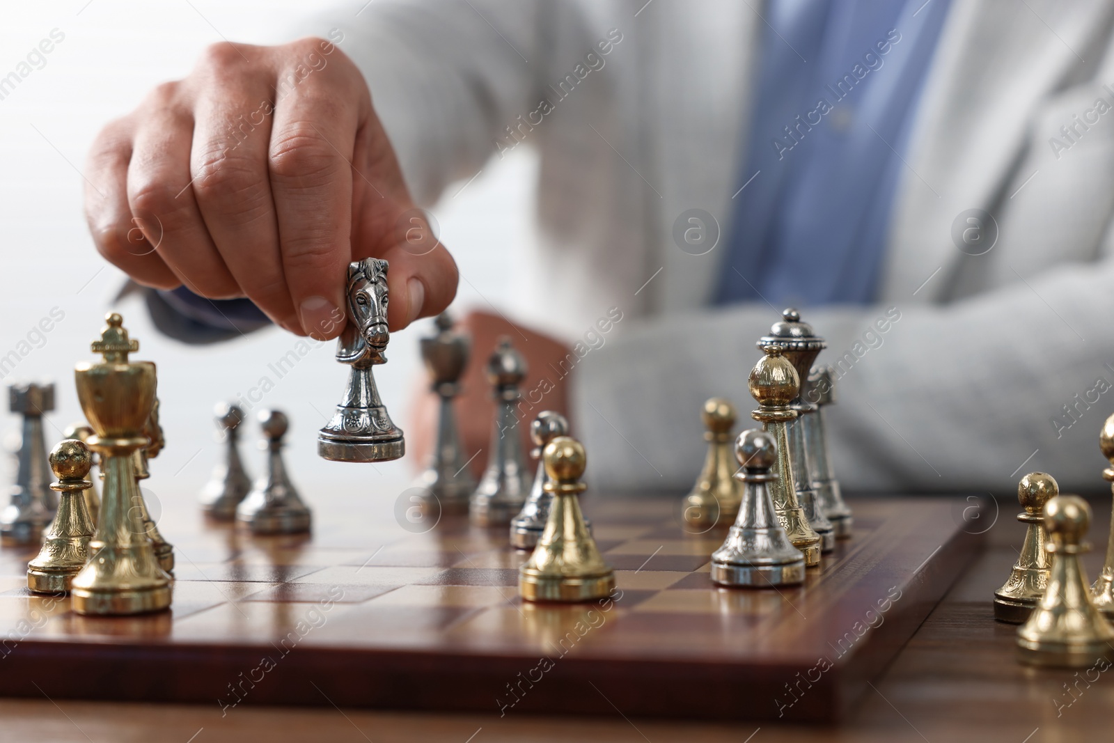 Photo of Man playing chess during tournament at table, closeup