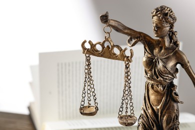 Photo of Symbol of fair treatment under law. Figure of Lady Justice on blurred background, closeup with space for text