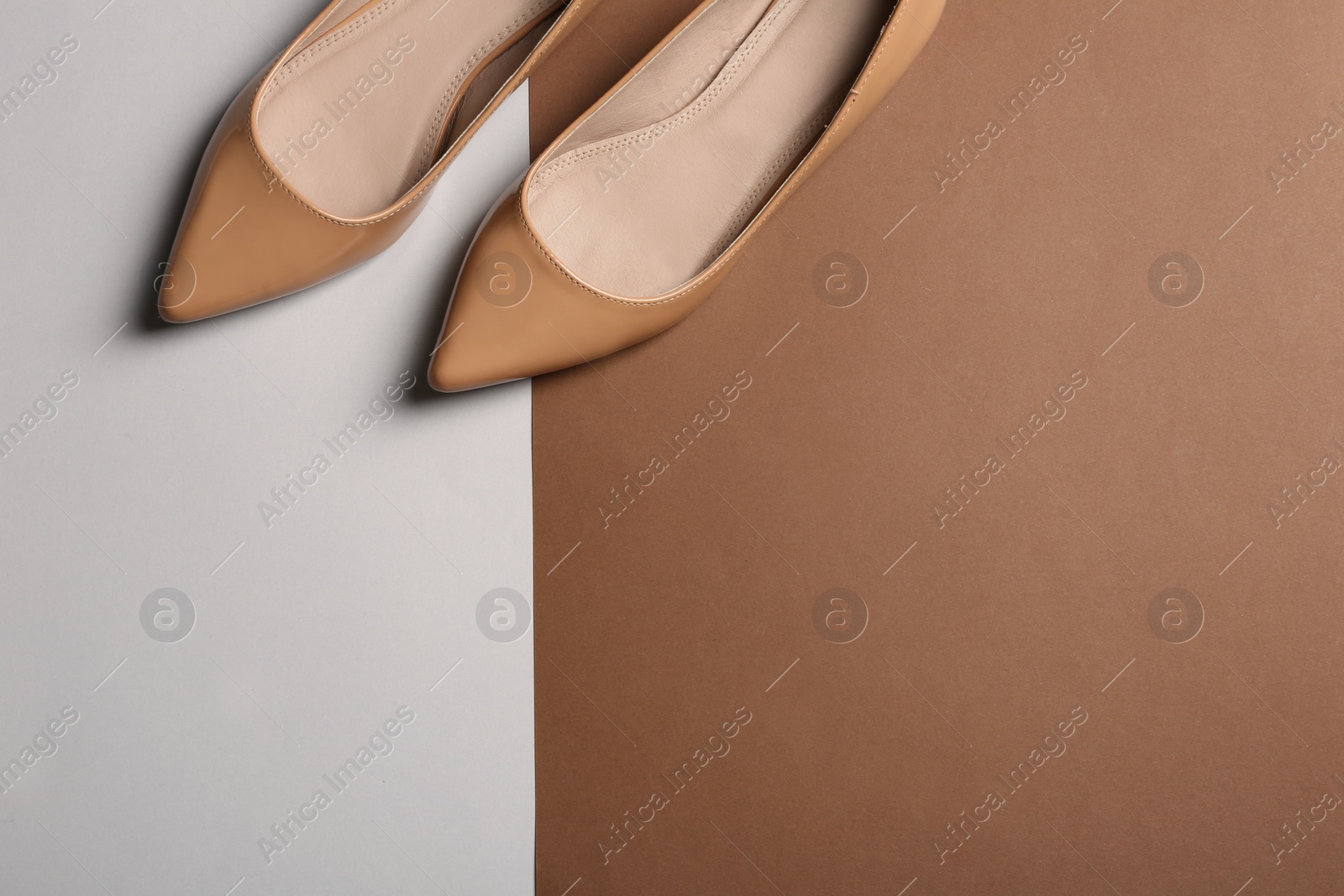 Photo of Stylish female flat shoes on color background, top view with space for text