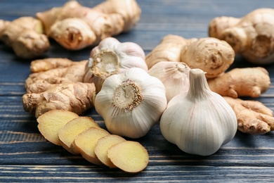 Photo of Ginger and fresh garlic on blue wooden table. Natural cold remedies