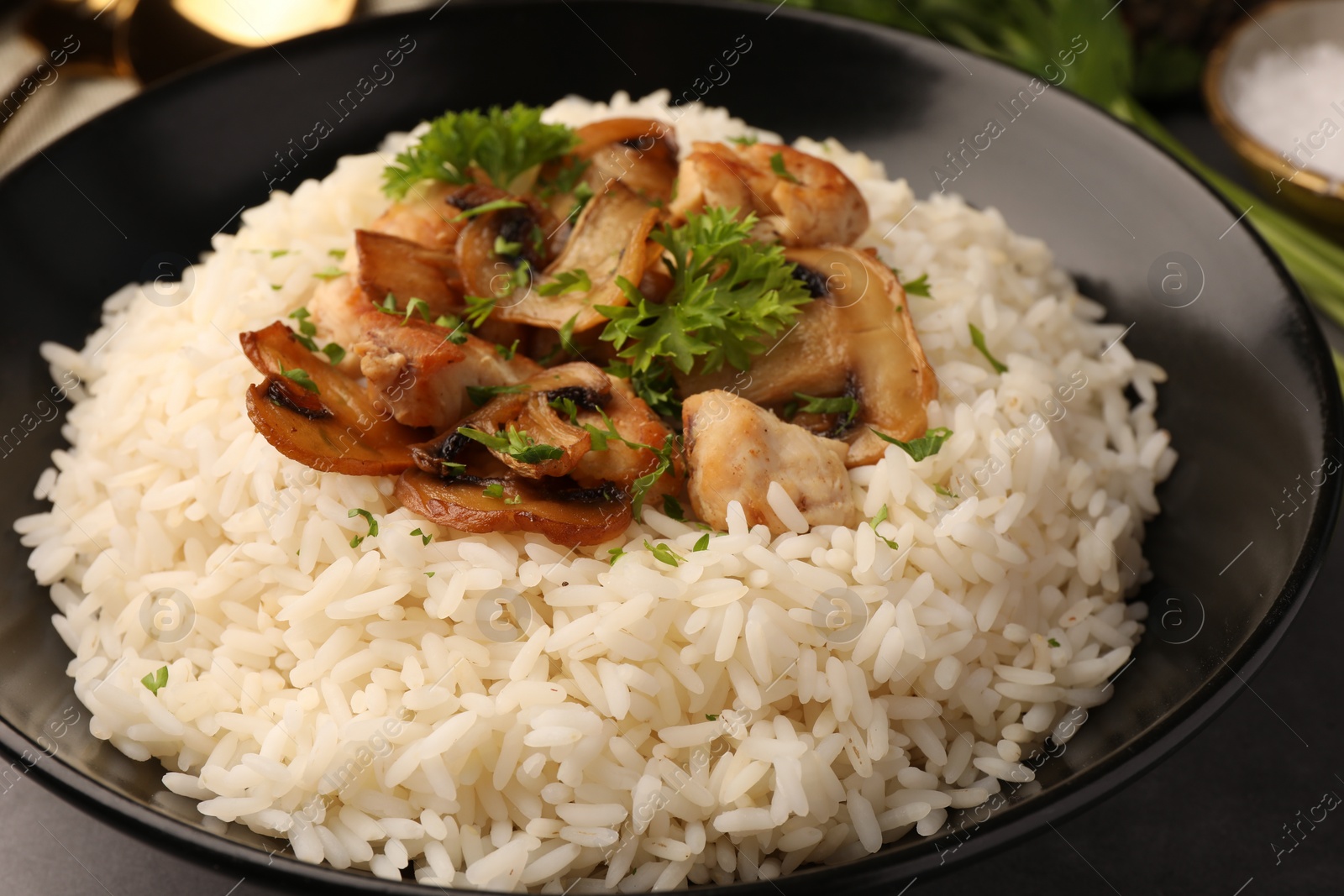 Photo of Delicious rice with parsley and mushrooms on plate, closeup