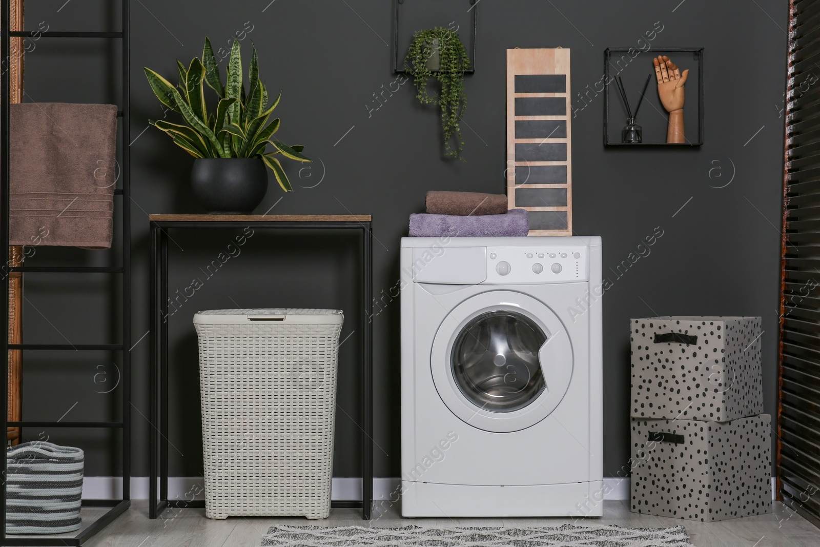 Photo of Stylish laundry room with washing machine. Interior design