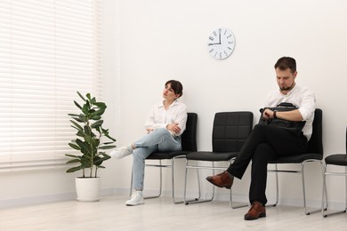 Photo of Man and woman waiting for job interview indoors