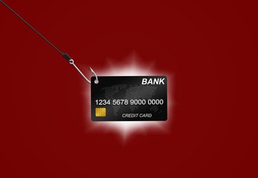 Image of Hook with credit card on red background. Cyber crime