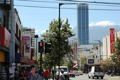 MONTERREY (NUEVO LEON), MEXICO - SEPTEMBER 29, 2022: Beautiful view of city street with people and cars on sunny day