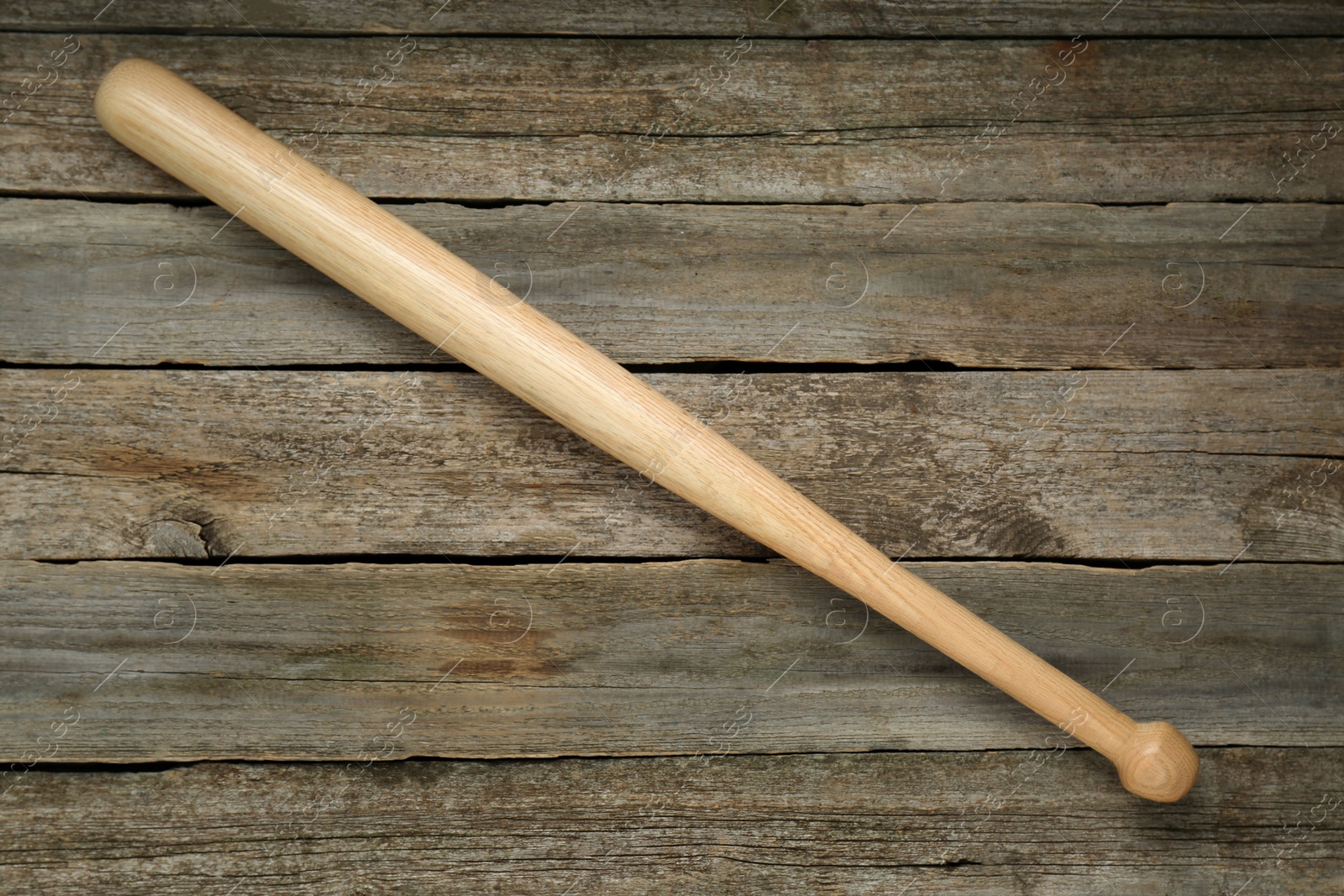 Photo of Baseball bat on wooden table, top view. Sports equipment