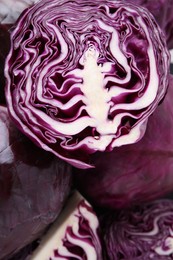 Photo of Cut and whole red cabbages as background, closeup