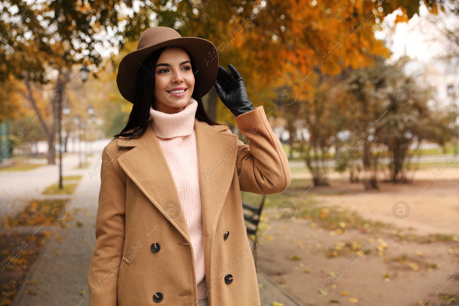 Photo of Young woman wearing stylish clothes in autumn park, space for text