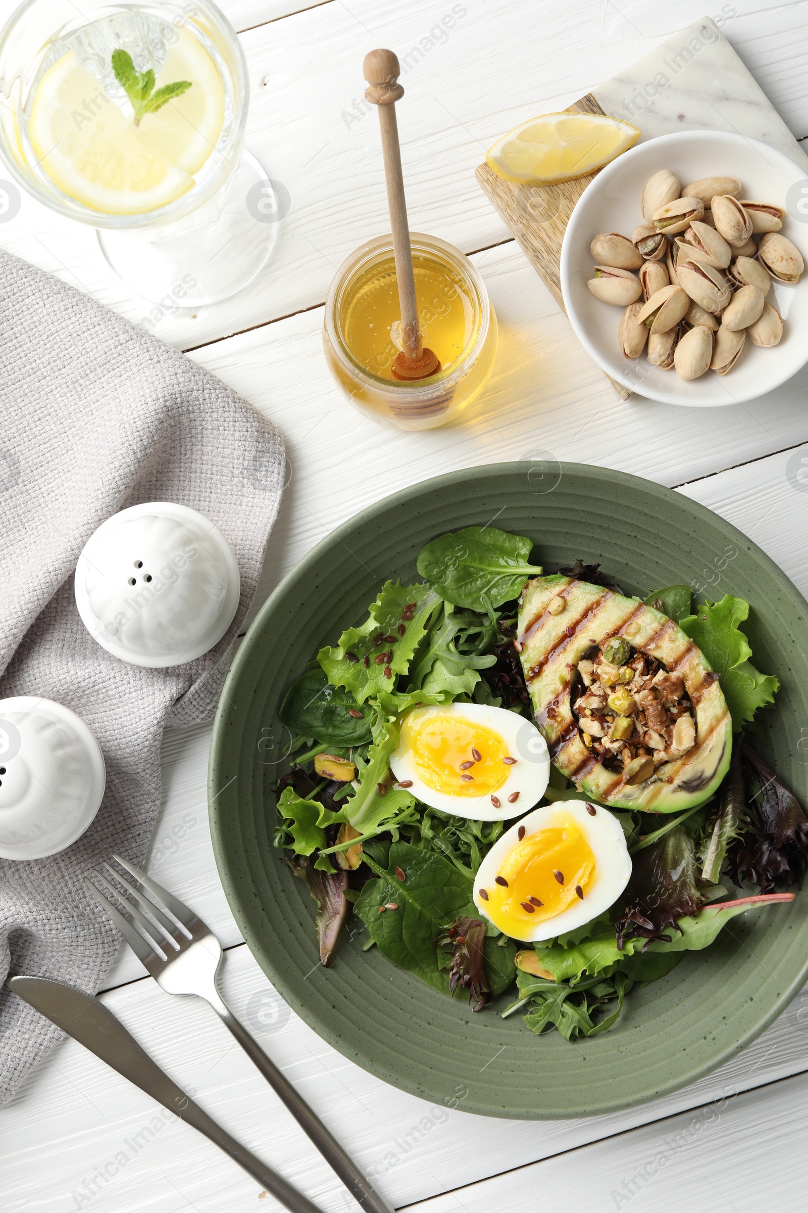 Photo of Healthy dish high in vegetable fats served on white wooden table, flat lay